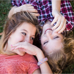 image of two teenage girls laying on grass