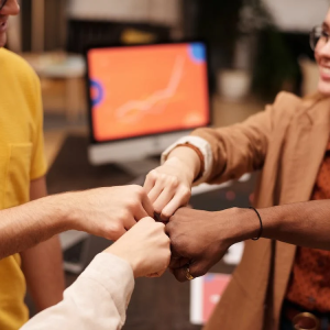image of four people fist bumping